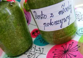 Dwa słoiki domowego pesto z młodej pokrzywy, gotowe do spożycia.